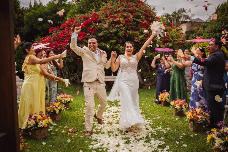 Novios celebrando con familiares y amigos al final de la ceremonia, un momento que refleja la importancia de una buena planificación de la lista de invitados.